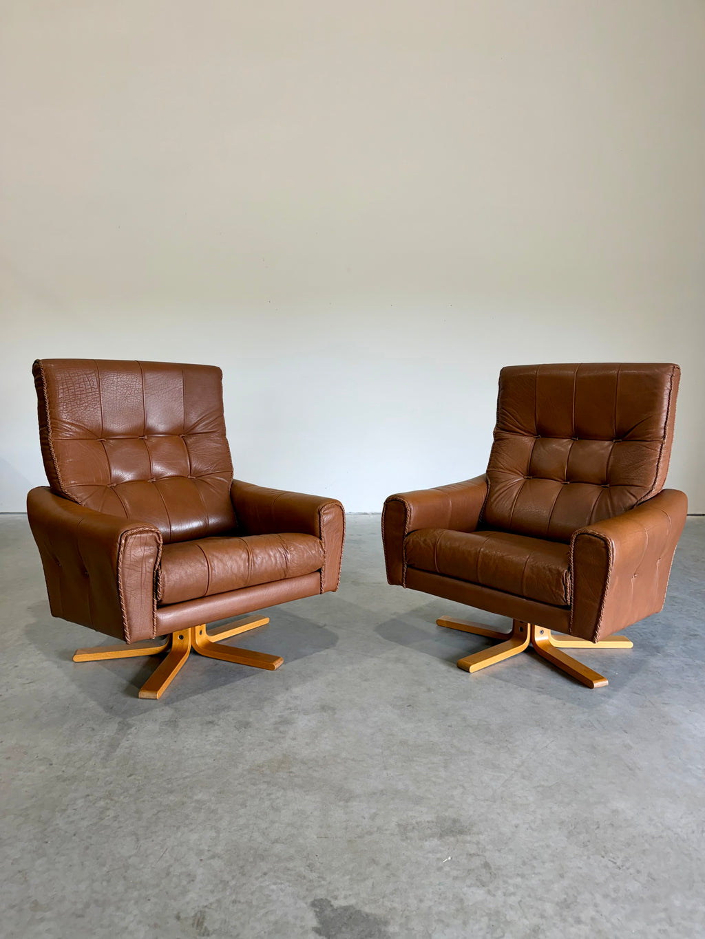 1970’s Danish Caramel Cowboy Leather and Beech Swivel Lounge Chair Pair