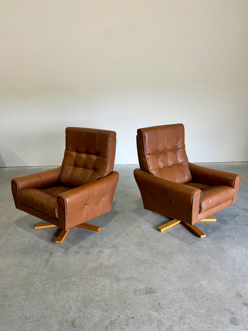 1970’s Danish Caramel Cowboy Leather and Beech Swivel Lounge Chair Pair